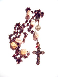 Copper colored crucifix, center and St Benedict medal.  Tiger eye beads with red veined marble nuggets and a 'drop of His blood'